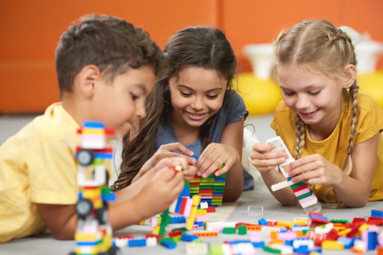 Happy kids playing with constructor at kindergarten.